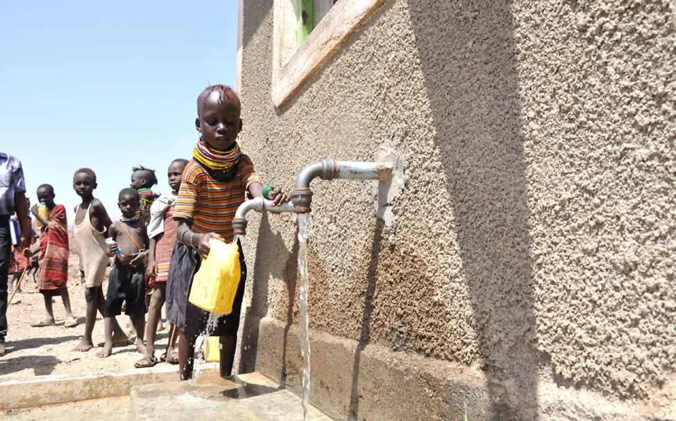 Es bildet sich eine Schlange vor der reparierten Wasserstelle | © UNICEFKenya/Oloo Dürre in Kenia: Ein Kind holt Wasser an einer reparierten Wasserstelle