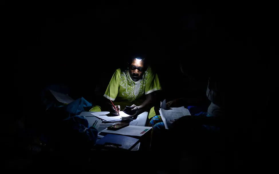 Auch den UNICEF-Mitarbeitern fehlt der Zugang zu Elektrizität | © UNICEF/Hatcher-Moore Südsudan: Eine UNICEF-Ernährungswissenschaftlerin macht sich Notizen im Licht einer Taschenlampe