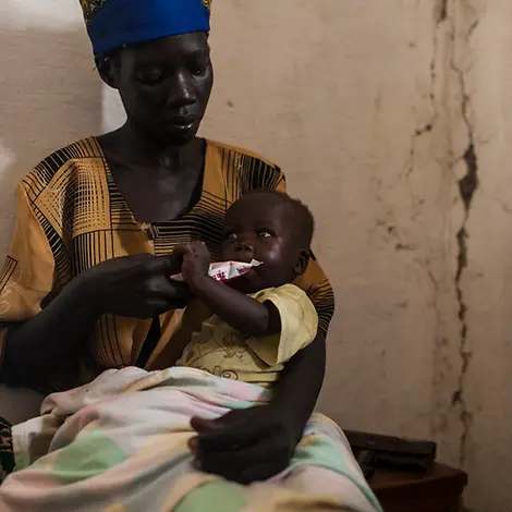 Erdnusspaste gibt geschwächten Kinder schnell wieder Energie. | © UNICEF/Adriane Ohanesian Eine Mutter füttert ihr geschwächtes Kind mit nahrhafter Erdnusspaste.