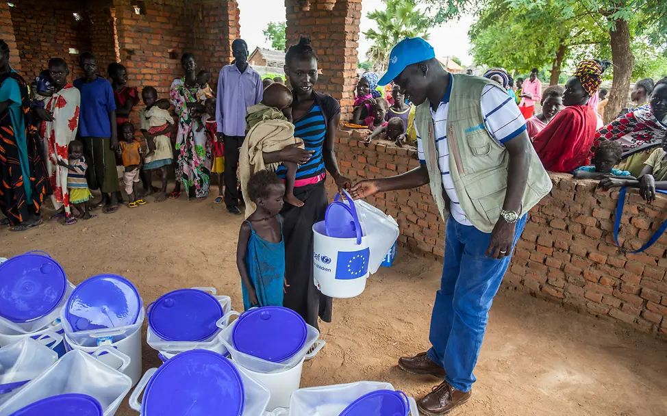 UNICEF-Helfer gibt einer Familie im Südsudan einen Wassereimer | © UNICEF South Sudan/2016/Rich Hilfsgüter gegen Cholera im Südsudan: Ein UNICEF-Helfer verteilt Wassereimer an eine Familie.
