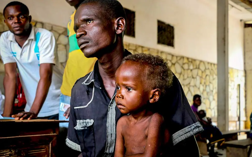 Pierre in der Gesundheitsstation: Er braucht dringend Spezialnahrung | © UNICEF/Le Du Pierre kann nicht mehr alleine essen und braucht Hilfe.