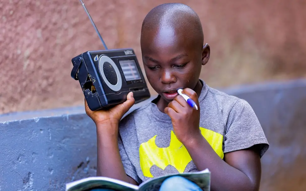 Ein Schüler aus Ruanda folgt gespannt der Unterrichtsstunde im Radio
