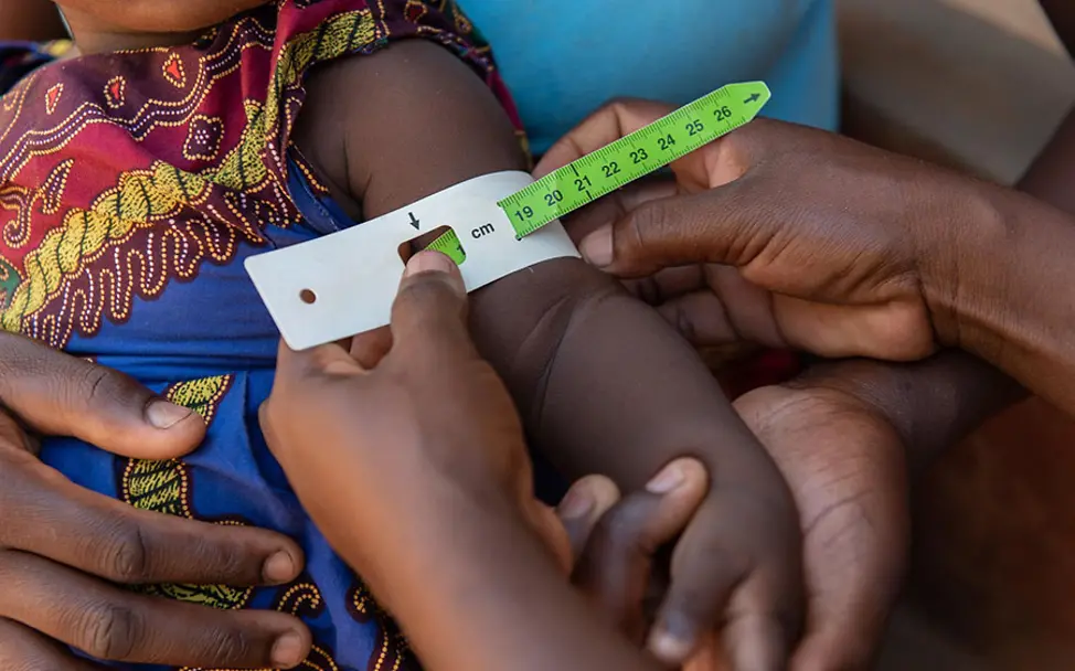 Mit dem MUAC-Maßband werden Kinder auf Mangelernährung untersucht. | © UNICEF Malawi: Esterys Wert auf dem MUAC-Maßband ist im grünen Bereich.