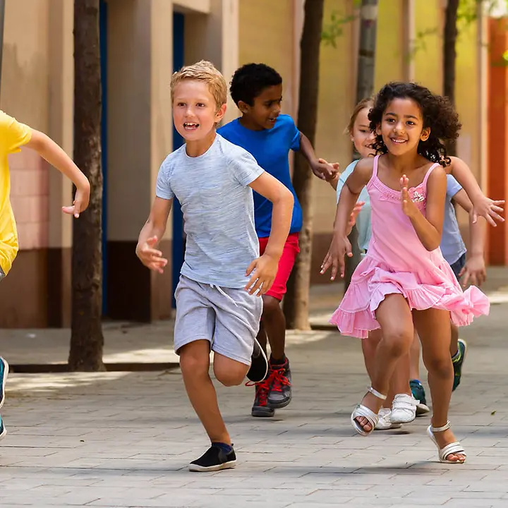 Kinderrechte in Kommunen | © Iakov Filimonovshutterstock Eine Gruppe von Schulkindern läuft über den Pausenhof.
