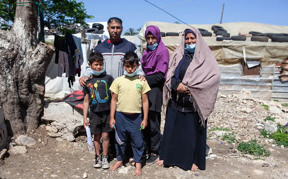 Libanon: Eine Familie vor ihrer Unterkunft in einem Flüchtlingslager | © UNICEF/UN0482291 Libanon Krise: Eine Familie vor ihrer Unterkunft in einem Flüchtlingslager