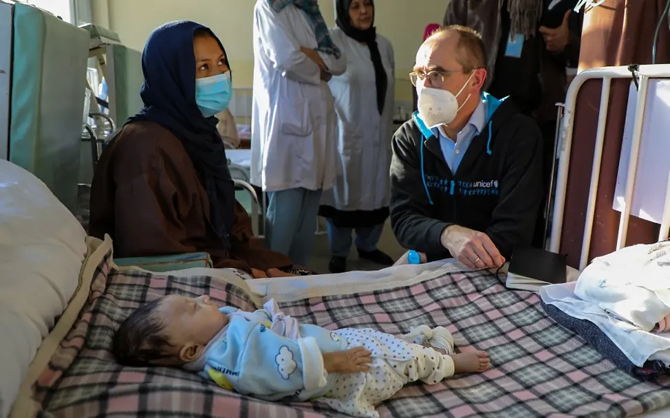 UNICEF Deutschland in Afghanistan | © UNICEF/Omid Fazel Christian Schneider, UNICEF Deutschland, sitzt neben Mutter und Kind im Krankenhaus in Afghanistan.