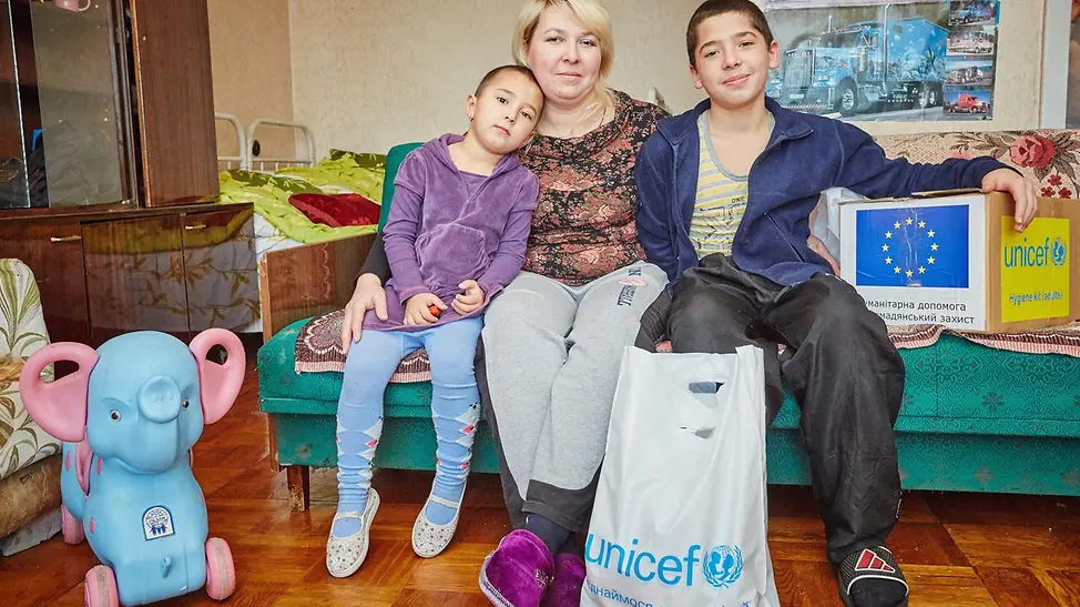 Neuer Start, neues Zuhause! | © UNICEF/Zmey Ukraine-Krieg Verlauf: Eine Familie sitzt auf dem Sofa in ihrem neuen Zuhause.