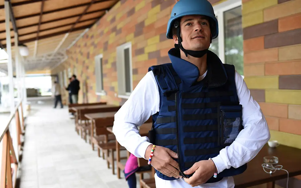 Am 28. April 2016 bereitet sich UNICEF-Botschafter Orlando Bloom auf den Besuch in der Ostukraine vor. | © UNICEF/Georgiev Ukraine-Krieg Verlauf: Orlando Bloom trägt Schutzhelm und Weste.