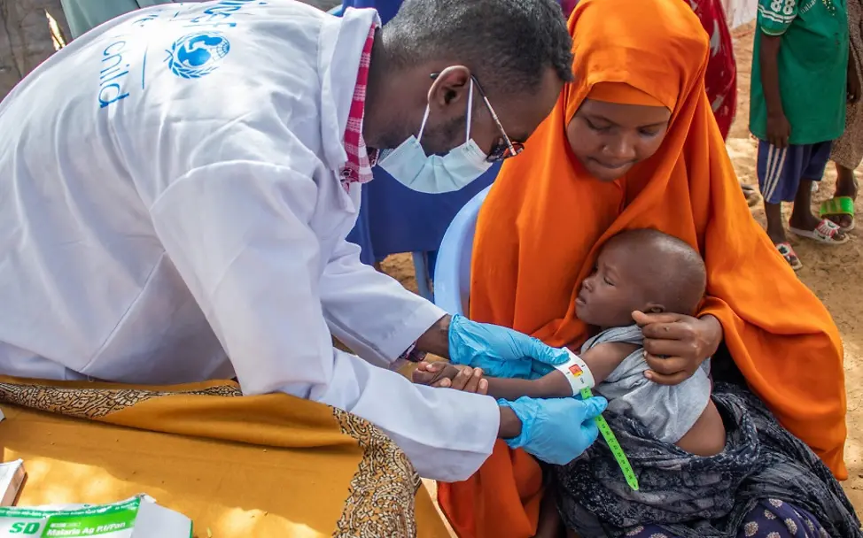 Foto-Reportage: Dürre am Horn von Afrika | © UNICEF/Sewunet Somalia: Ein Kind wird auf dem Arm seiner Mutter auf Mangelernährung untersucht.