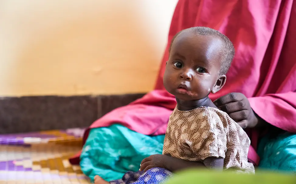 Marwo in einem Stabilisierungszentrum eines Krankenhauses in Mogadischu I UNICEF/Fazel Somalia: Ein kleines Mädchen sitzt auf dem Boden und schaut in die Kamera.