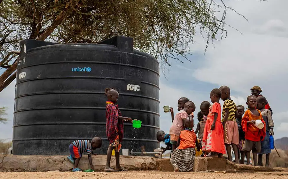 Schüler*innen in Kenia holen Wasser an einem UNICEF-Wassertank. | © UNICEF/Wahome Kenia Hunger: Ein von UNICEF installiertes solarbetriebenes Wassersystem an einer Schule in Kenia.