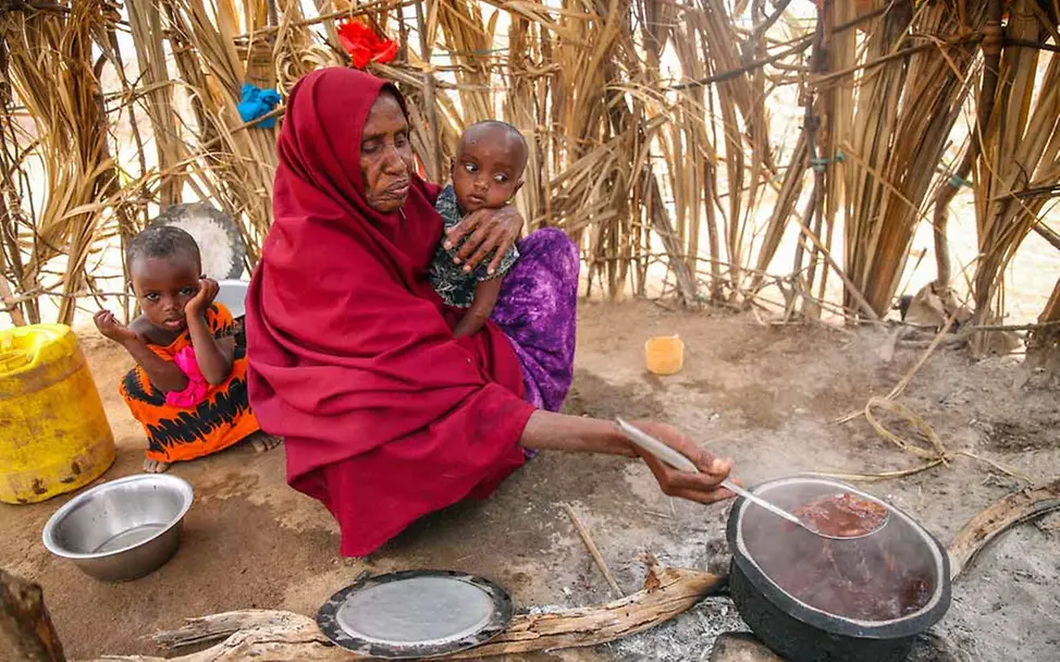 Eine Frau kocht das Mittagessen für ihre Enkelkinder. | © UNICEF/Ekwam Kenia Hungerkrise: Eine kenianische Frau kocht das Essen für ihre Enkelkinder.