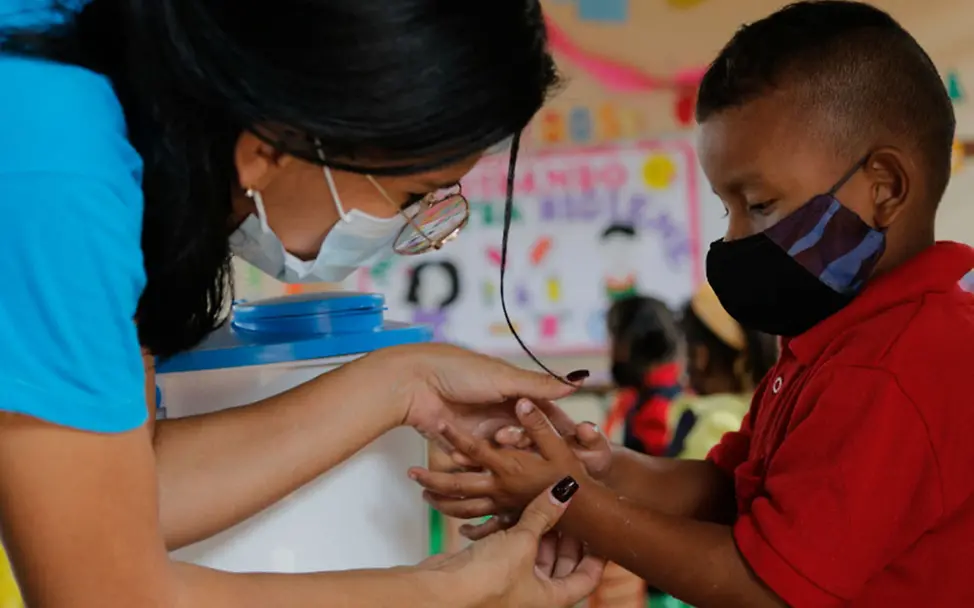 Eine UNICEF-Hygiene-Expertin erklärt einem Jungen das richtige Händewaschen. | © UNICEF/Núñez Venezuela Armut: Eine UNICEF-Mitarbeiterin zeigt einem Jungen das Händewaschen.
