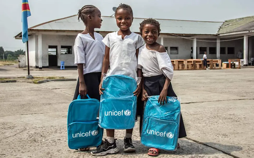 Drei Mädchen stehen mit UNICEF-Rucksäcken auf ihrem Schulhof | © UNICEF/Wenga Nothilfe Demokratische Republik Kongo: UNICEF hilft Kindern, wieder zur Schule zu gehen.
