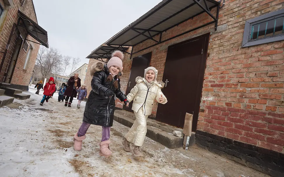 Kinder auf dem Weg in den Schutzraum eines Kindergartens. 
