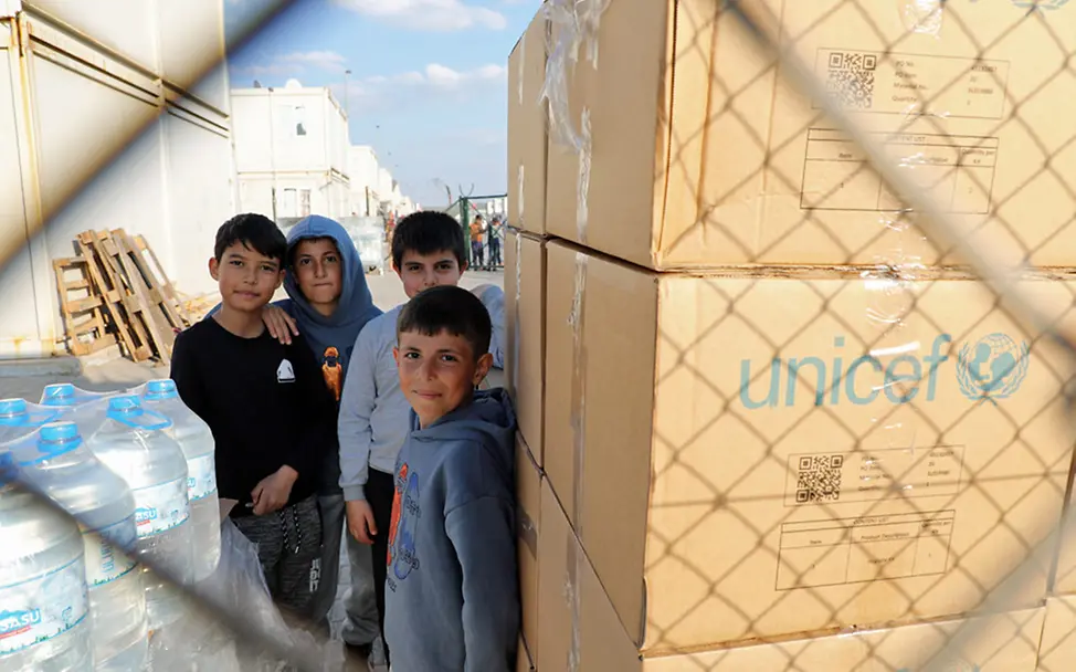 Nothilfe nach den Erdbeben für Kinder in der Türkei | © UNICEF/Ergen Erdbeben Syrien Türkei: Kinder in der Türkei stehen neben großen UNICEF-Kartons mit Hilfsgütern