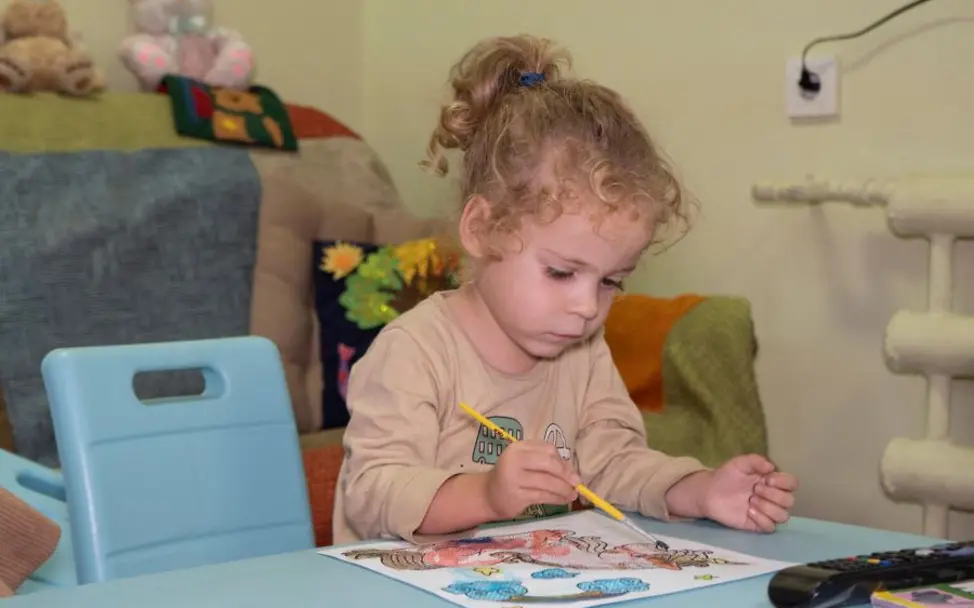 Ukraine: Alltag in einem unterirdischen Kindergarten | © UNICEF/Mala Jahrestag Ukraine-Krieg: Ein Kind malt ein Bild.