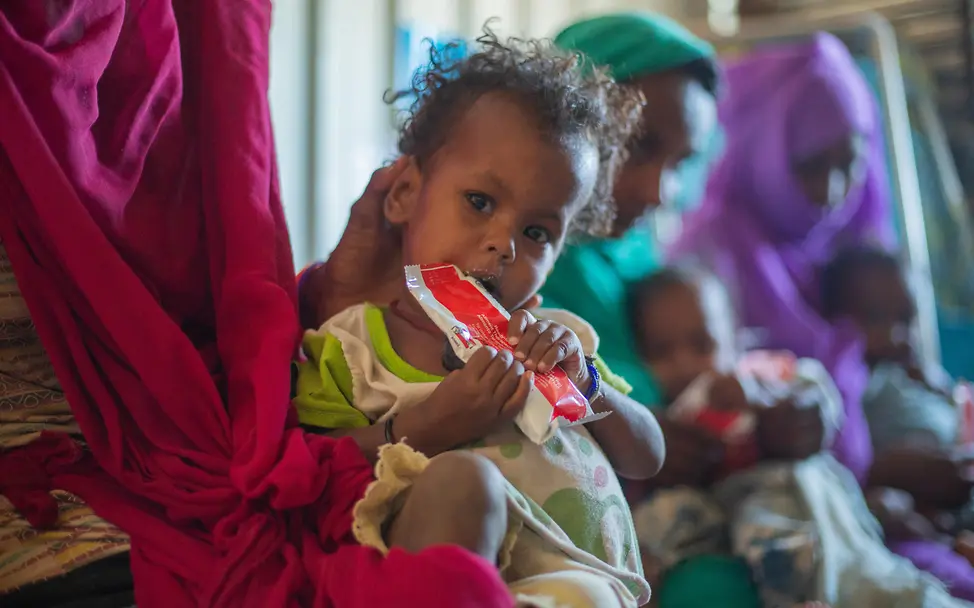 Ein Kind wird mit Erdnusspaste versorgt | © UNICEF/UNI529937/Elfatih Ein Kind wird mit Erdnusspaste versorgt