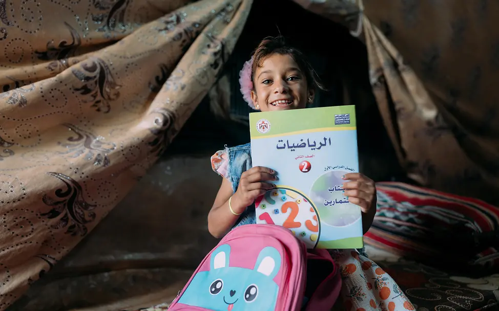 Ein kleines Mädchen in Jordanien mit seinen Schulsachen