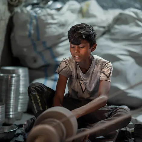 Ein Kind arbeitet in einer Silberpolierfabrik in Bangladesh
