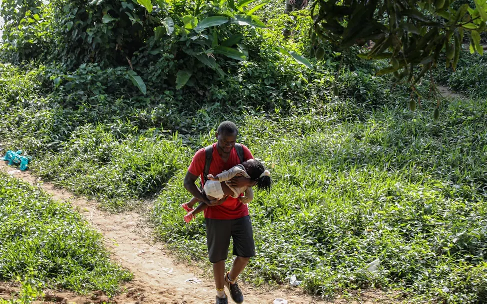 Vater und Kind kommen erschöpft nach der Überquerung des Darien Gap in Bajo Chiquito, Panama, an. | © UNICEF/UN0433742/Moreno Gonzalez Weltflüchtlingstag: Vater und Kind kommen erschöpft nach der Überquerung des Darien Gap in Bajo Chiquito, Panama, an.
