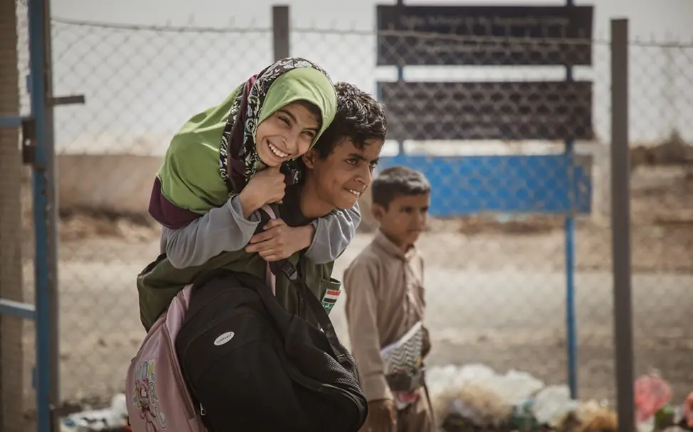 Jemen: Al-Bara'a, der seine Schwester trägt, um sie von der Schule nach Hause zu bringen | © UNICEF/Alhamdani Weltflüchtlingstag: Jemen: Al-Bara'a, der seine Schwester trägt, um sie von der Schule nach Hause zu bringen.