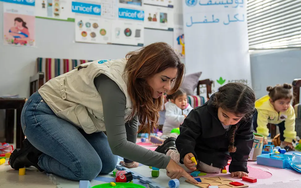 Vertriebene Kinder im südlichen Libanon können in einer UNICEF-Einrichtung in Ruhe spielen | © UNICEF/Choufany Libanon Krise: Eine UNICEF-Mitarbeiterin kümmert sich spielerisch um ein geflüchtetes Mädchen.
