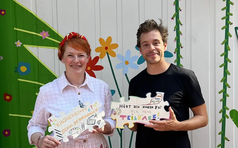 Weltkindertag 2025: Tobias Krell und Enie van de Meiklokjes halten kreativ gestaltete Kinderrechte-Puzzleteile in den Händen Weltkindertag: Tobias Krell und Enie van de Meiklokjes halten kreativ gestaltete Kinderrechte-Puzzleteile in den Händen