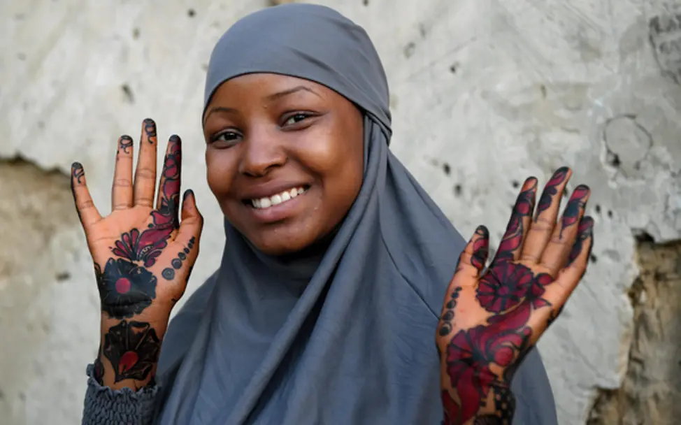 EIn junges Mädchen zeigt ihre mit Henna bemalten Hände