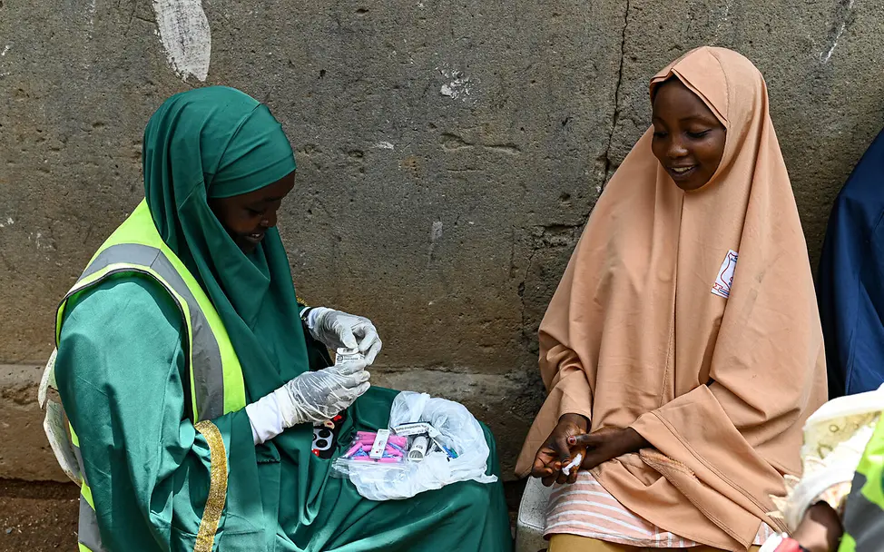 HIV Tests für Mädchen und Frauen | © UNICEF/UNI610657/Adesegun Zwei junge Frauen sitzen sich gegenüber und bereiten HIV Testkits vor