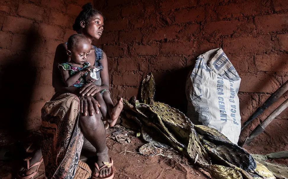 Mutter und Tochter in ihrem Zuhause | © UNICEF/UNI658450/Andrianantenaina Eine Mutter mit ihrer kleinen Tochter auf dem Arm in ihrem Zuhause