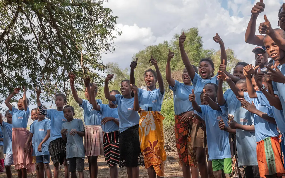 Kinder die am Lifeskill Programm mitmachen | © UNICEF/UNI658494/Andrianantenaina Kinder mit hellblauen T-Shirts zeigen mit dem Daumen nach oben
