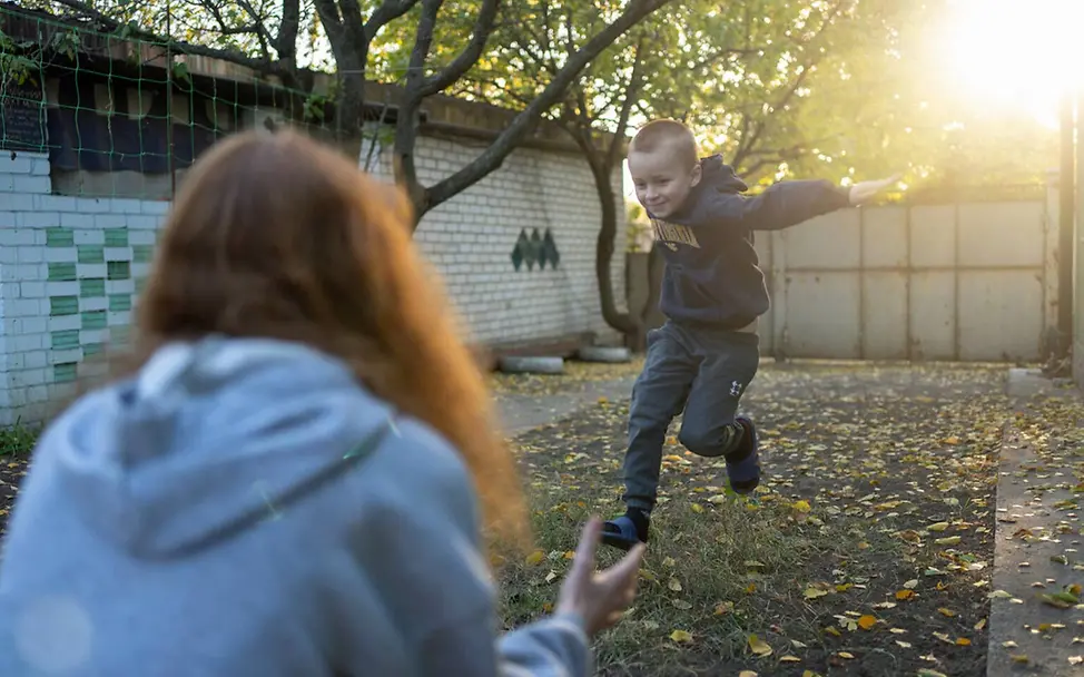 Zwei Geschwister spielen im Hof ihres Hauses | © UNICEF/Filippov Ukraine Winter Hilfe: Zwei geflüchtete Geschwister spielen im Hof ihres Hauses
