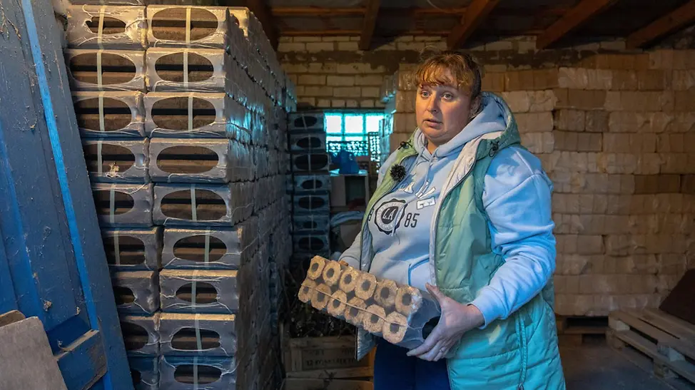 Diese Mutter hat für den Winter einen Vorrat an Briketts zum Heizen bekommen | © UNICEF/Filippov Ukraine Winter Hilfe: Familien bekommen von UNICEF Hilfsgüter wie Briketts, um im Winter heizen zu können