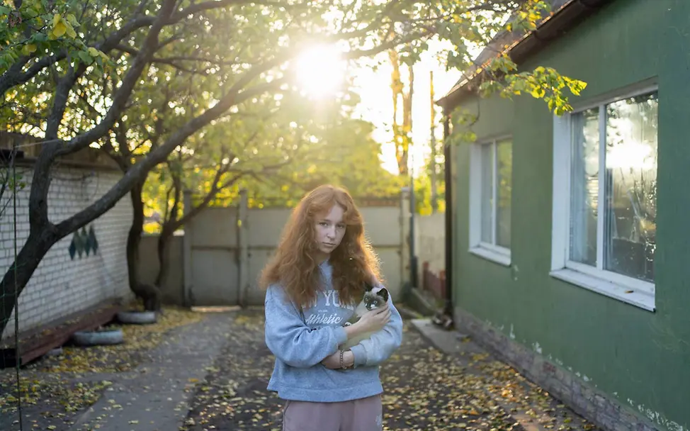 Eine Jugendliche hält eine Katze im Arm | © UNICEF/Filippov Ukraine Winter Hilfe: Eine Jugendliche in der Nähe der Front mit einer Katze im Arm