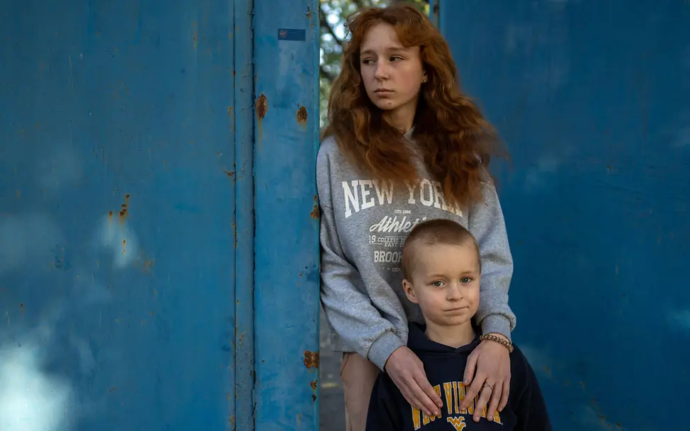 Zwei Geschwister stehen am Tor ihrer Unterkunft in der Ukraine | © UNICEF/Filippov Ukraine Winter Hilfe: Diese Geschwister sind vor dem Krieg in der Region Charkiw geflohen