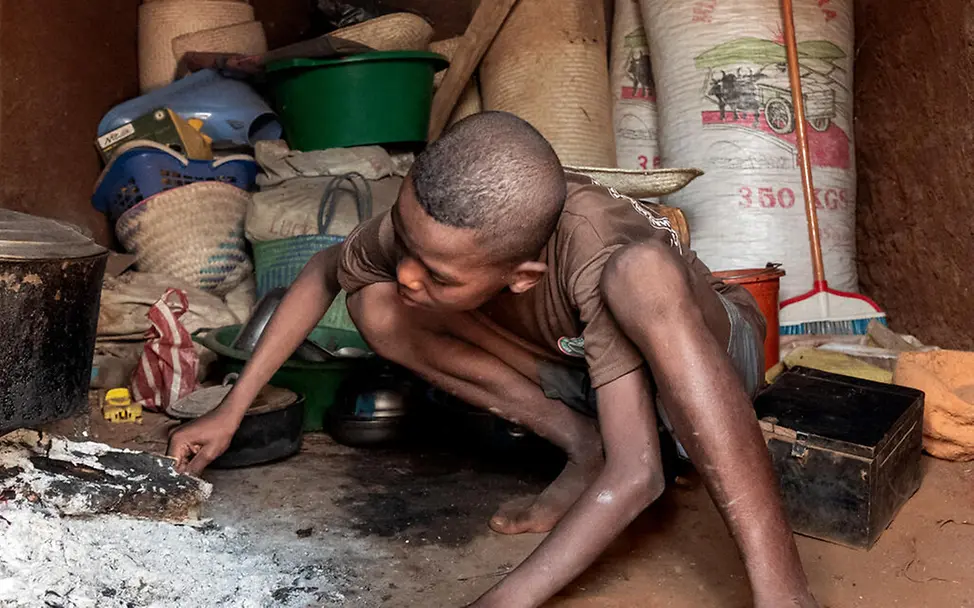 Zafia in der Küche seines Hauses | © UNICEF/UNI658436/Andrianantenaina Ein Junge hockt in der Küche seines Hauses