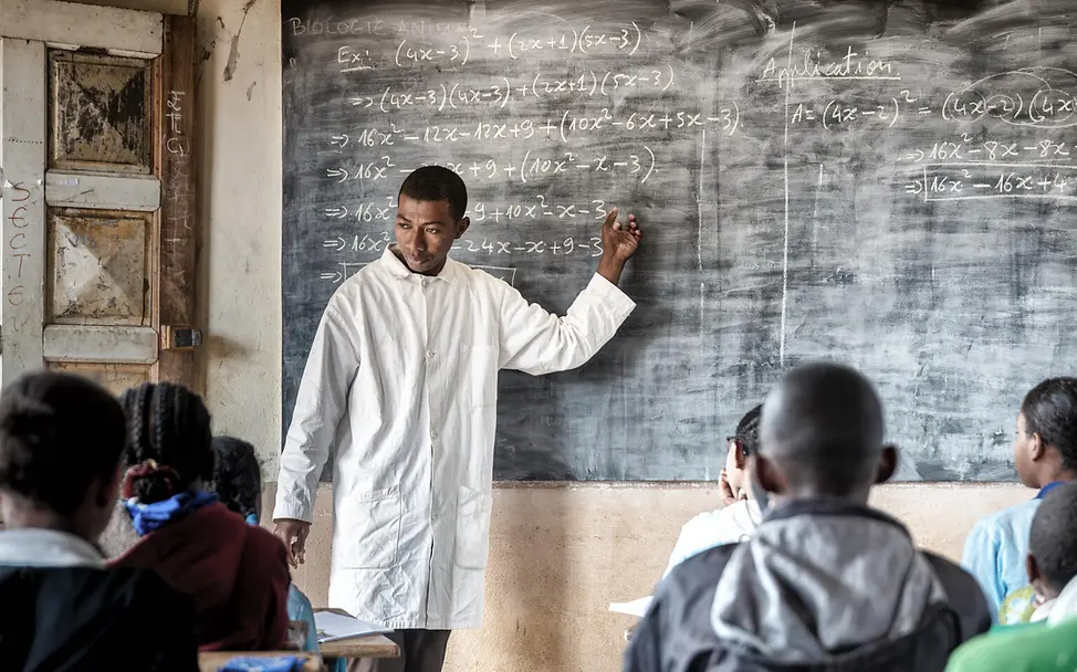 Schulunterricht in Madagaskar | © UNICEF/UNI658287/Andrianantenaina Ein junger Lehrer an einer Tafel mit mathematischen Formeln