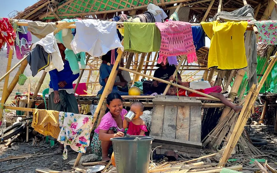 Eine Mutter gibt ihrem Kind etwas zu trinken. | © UNICEF/Naing Linn Soe Klimawandel für Kinder erklärt: Mutter mit ihrem Kind