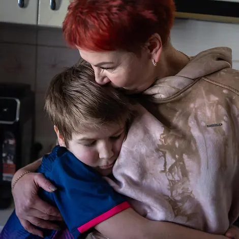 Andrii aus Cherson umarmt seine Mutter | © UNICEF/UNI738309/Filippov Ein Junge umarmt seine Mutter