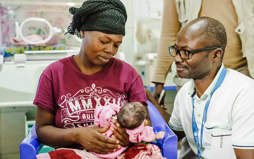 Eine Mutter kümmert sich mit einem UNICEF-Helfer um ihr verletztes Baby | © UNICEF/Benekire Demokratische Republik Kongo Nothilfe: Eine Mutter kümmert sich mit einem UNICEF-Helfer um ihr verletztes Baby