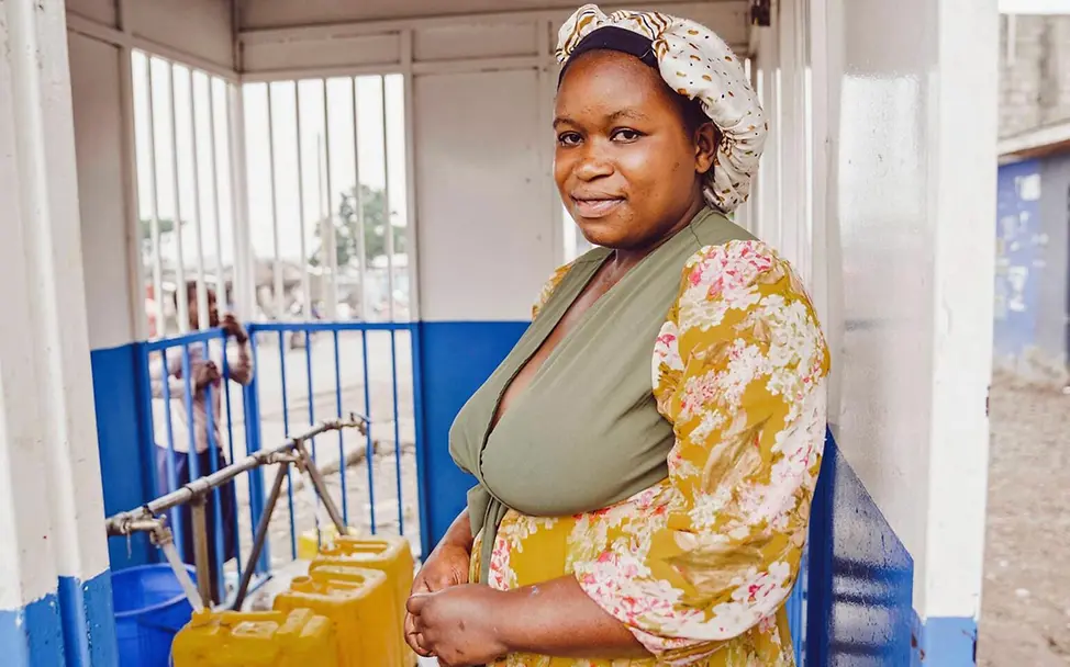Eine Frau hilft an einer Wasserstelle Familien beim Abfüllen von sauberem Wasser | © UNICEF/Benekire Demokratische Republik Kongo Nothilfe: Eine Frau hilft an einer Wasserstelle Familien beim Abfüllen von sauberem Wasser