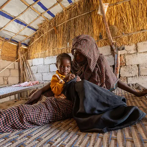 Walaa und ihre Mutter | © UNICEF/UNI681097/Elfatih Eine Mutter sitzt mit ihrer Tochter auf einem Bett