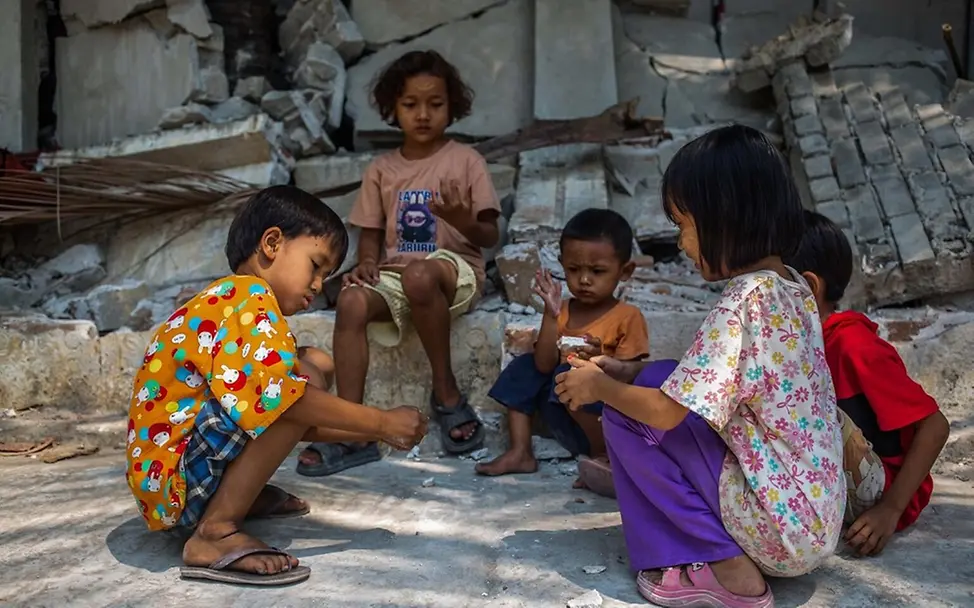 Poe Kyal Sin Lin (6) und andere Kinder sitzen vor einem eingestürzten Gebäude. | © UNICEF/Htet Hilfe für Myanmar: Poe Kyal Sin Lin (6) und andere Kinder sitzen vor einem eingestürzten Gebäude.