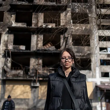 Die 14-jährige Angelina steht vor einem beschädigten Wohnhaus. Ukraine Teenager: Die 14-jährige Alina steht vor einem beschädigtem Wohnhaus