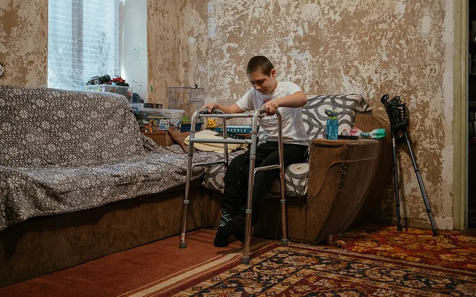 UNICEF/Pashkina | Nazar muss das Laufen wieder lernen Ukraine Teenager: Nazar steht mit Hilfe seiner Gehhilfe langsam auf