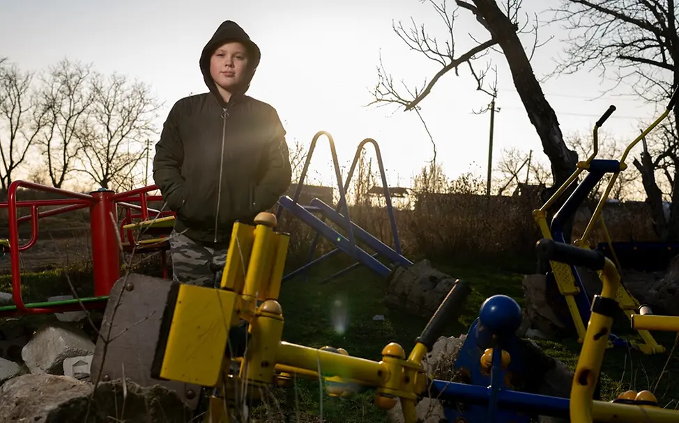 UNICEF/Filippov | Der Kindergarten in Timofiis Dorf wurde bei einem Angriff zerstört Ukraine Teenager: Timofii steht auf einem zerstörten Kindergarten in seinem Heimatdorf