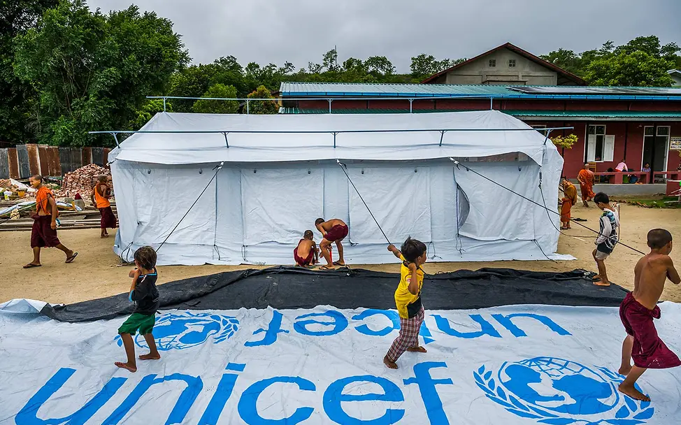 Kinder packen spielerisch beim Aufbau eines großen UNICEF-Zeltes mit an | © UNICEF/Oo Myanmar Erdbeben spenden: Kinder packen spielerisch beim Aufbau eines großen UNICEF-Zeltes mit an.