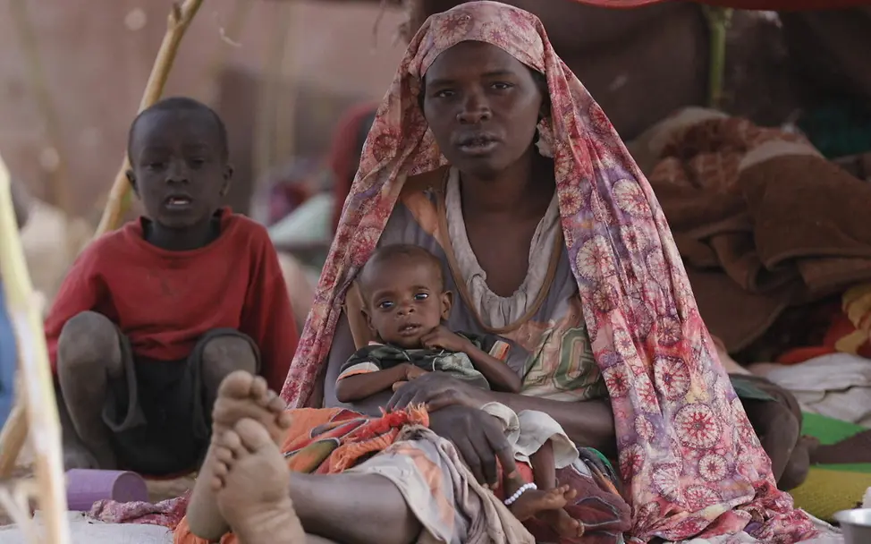 Hawa hält ihren kleinen Sohn Waleed in einer Notunterkunft in Tawila | © UNICEF/Jamal Hawa hält ihren kleinen Sohn Waleed in einer Notunterkunft in Tawila