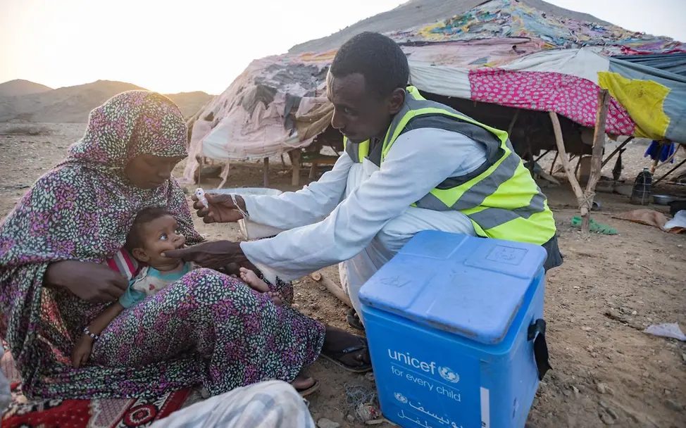 Im Barqiq Valley im Sudan impft ein UNICEF-Helfer ein sieben Monate altes Baby | © UNICEF/Elfatih Sudan: Helfer Sheeba war mit Kamelen und Eseln unterwegs, um die kleine Orshia zu impfen.